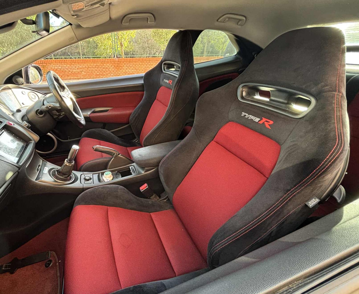 Interior del coupé con asientos deportivos rojos